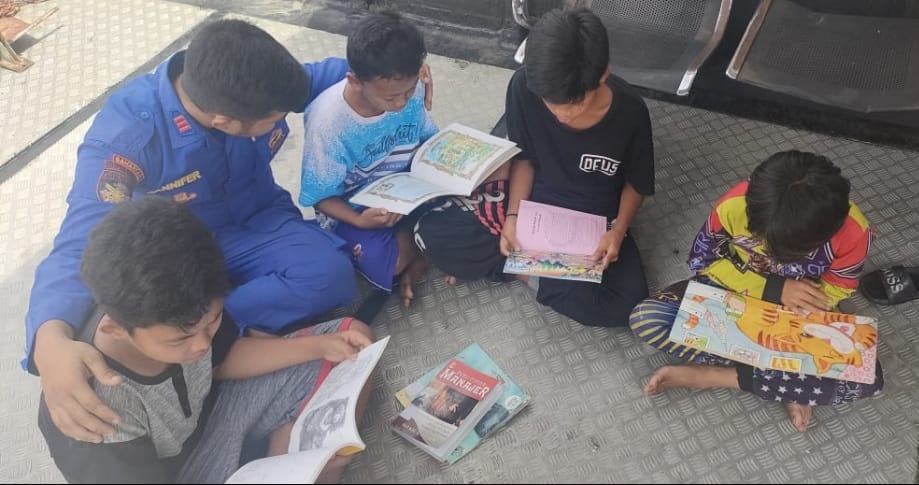 Bangkitkan Semangat Baca , Personel Kapal XVIII-2002 Ditpolairud Ajak Anak Bantaran Sungai Membaca Buku Di Kapal