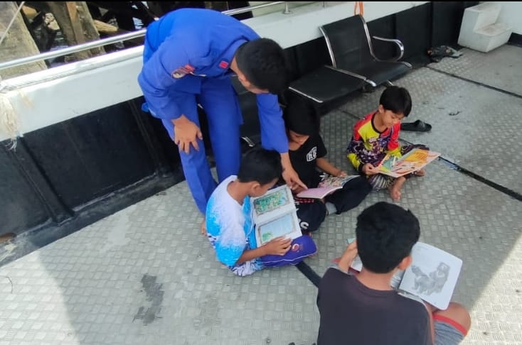 Bangkitkan Semangat Baca , Personel Kapal XVIII-2002 Ditpolairud Ajak Anak Bantaran Sungai Membaca Buku Di Kapal